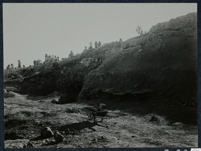 Excavation of the theatre at Soli, with people working along the upper slope and wheelbarrows in the foreground.
