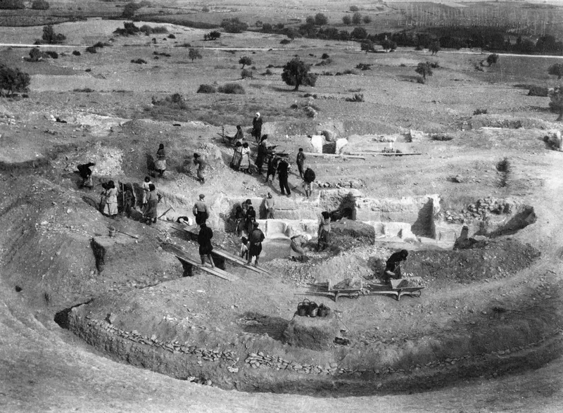 Excavation of the proskenion at the theatre at Soli, with many workers, wheelbarrows and planked walkways
