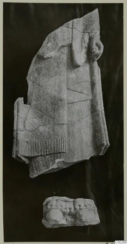 Limestone sculpture fragment of a figure in a fringed garment, with a smaller carved piece below, from Vouni