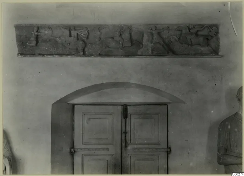 Marble relief of horsemen fighting, from Soli, fixed high on a wall above an arched double door