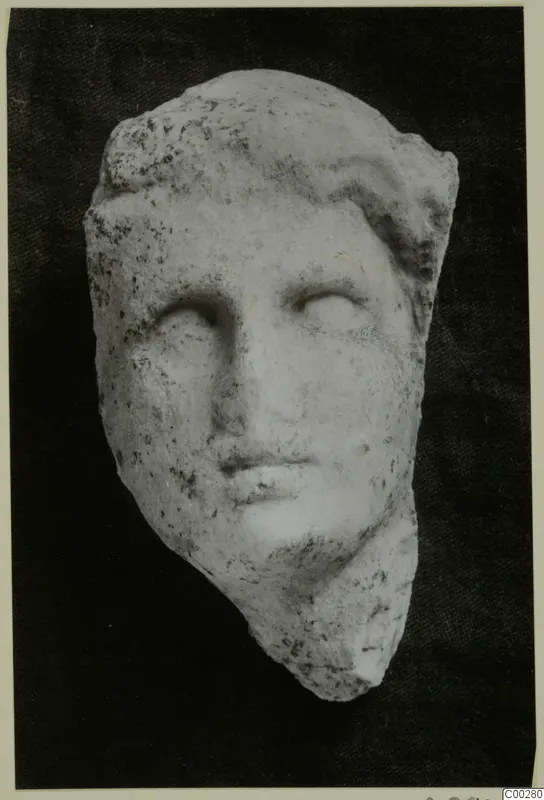 Marble head sculpture from Soli, shown frontally against a dark background