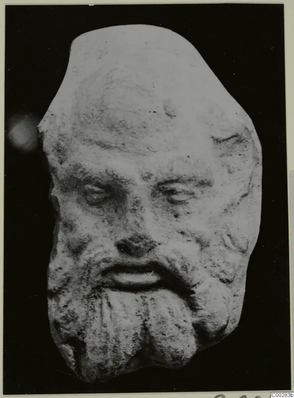 Small terracotta head of a bearded man from Soli, shown frontally against a black background
