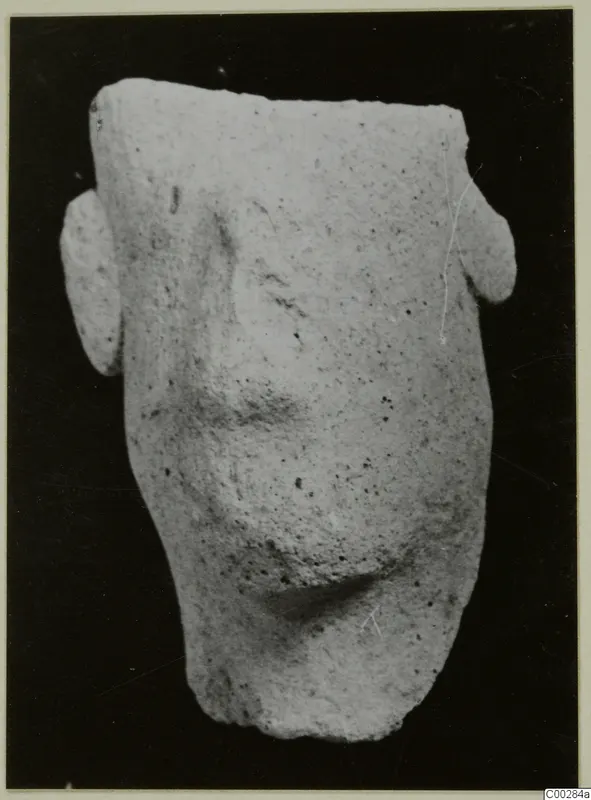 Terracotta figurine fragment from Soli with two side projections, photographed on a black background
