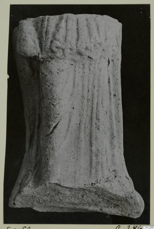 Fragment of a small figure with vertical folds, found at Soli, photographed against a black background