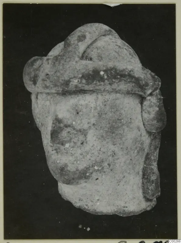 Terracotta figurine fragment from Soli with a broad band across the top, shown against a dark background.
