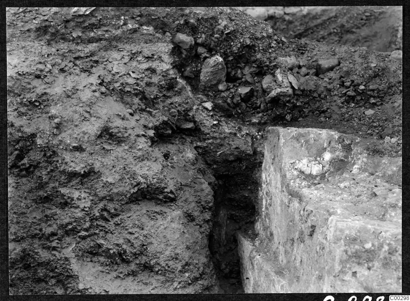 Excavation at Soli: a soil section beside squared stone blocks, with loose stones heaped along the top of the cutting
