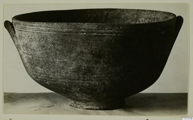 Pottery Red Slip bowl from Lapithos, Kastros tombs, with two small handles, shown in side view