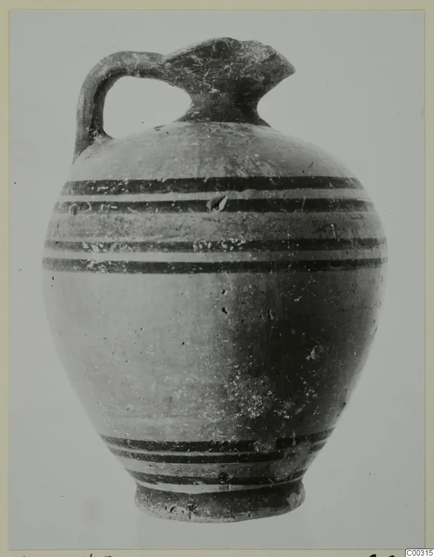 Pottery juglet with a single strap handle, a trefoil-like spout and horizontal dark bands painted around the body.