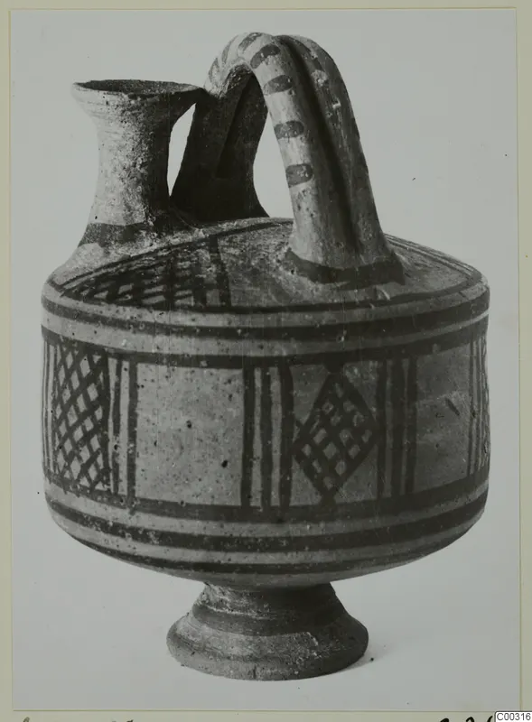 Pottery Bichrome I askos from the Lapithos Kastros tombs, with a spout, strap handle and painted bands and lattice panels.