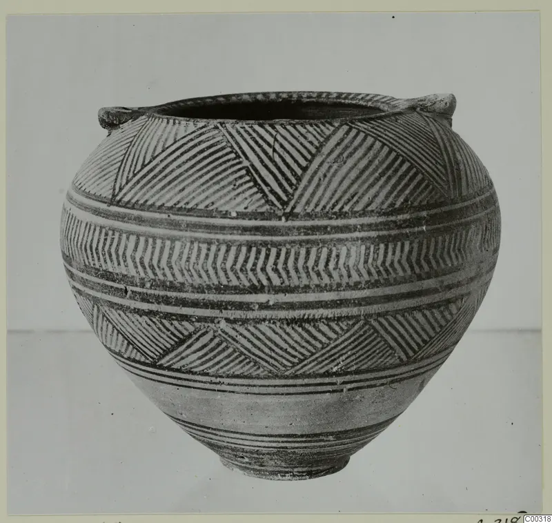 Painted pottery vessel with two small handles, banded with hatched triangles and chevrons, shown from the side.