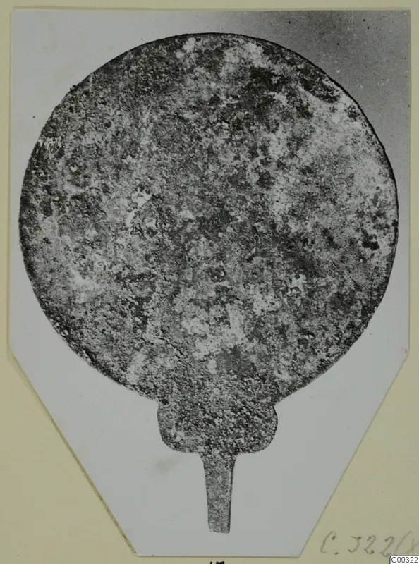 Corroded metal disc with a short tang, possibly a bronze mirror, from Tomb 59 at Marion