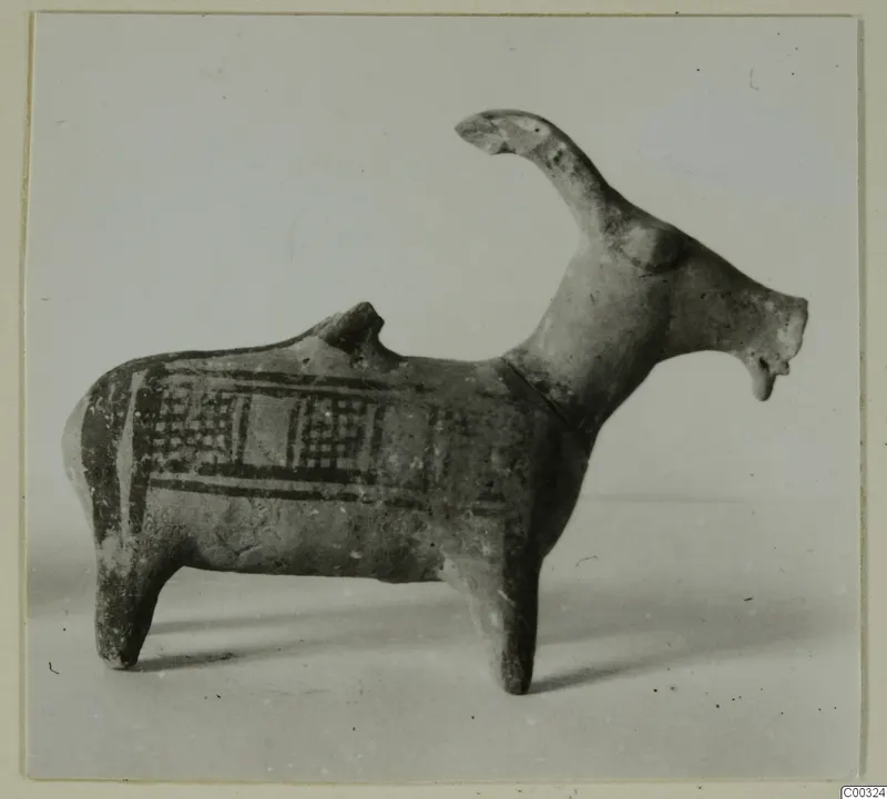 Pottery figure of an animal, possibly a goat, with a long raised neck and a painted body panel of cross-hatching and bands.
