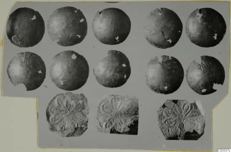 Ten thin round gold discs and three embossed gold pieces with a radiating petal-like pattern, shown on a grey card