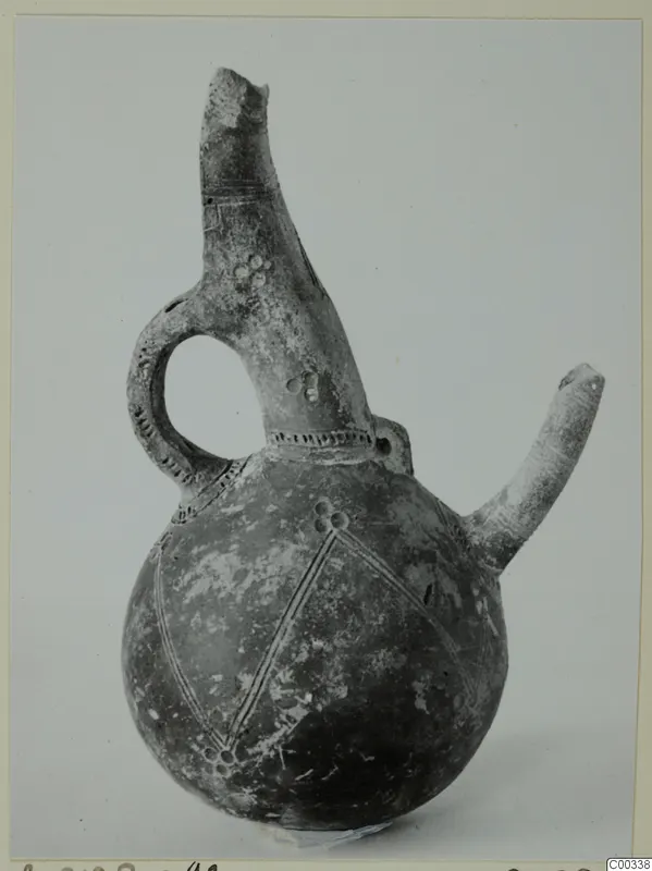 Red Polished III jug from Lapithos, with a side spout, loop handle and incised diamond pattern