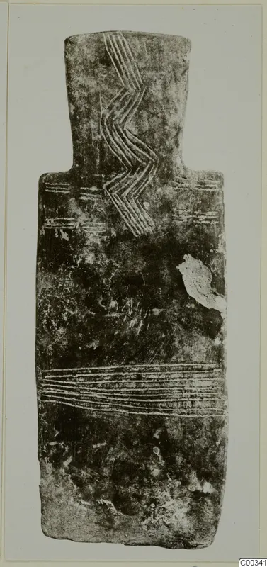 Back of a plank-shaped idol from Lapithos, with incised zigzag and horizontal lines on a dark, worn surface