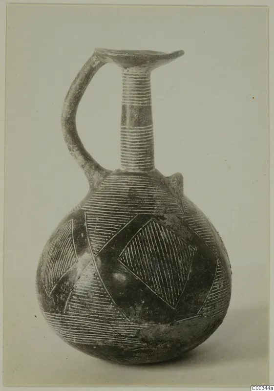 Red Polished II jug with a single handle, a trefoil-type mouth, and incised hatched triangles and diamonds on its body.