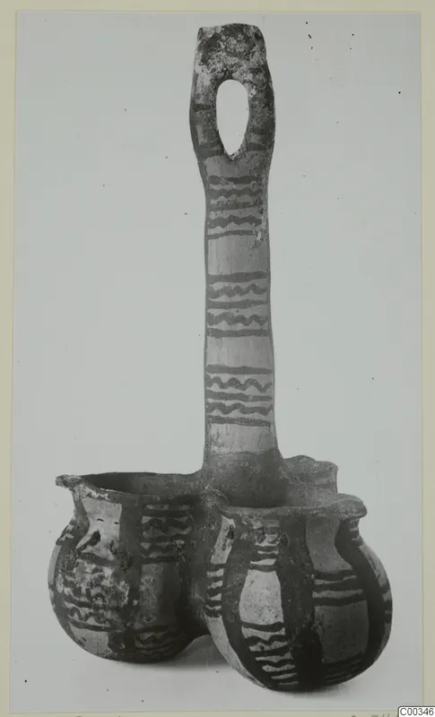 Coupled pottery vessel from Lapithos with a tall loop handle and dark wavy painted bands