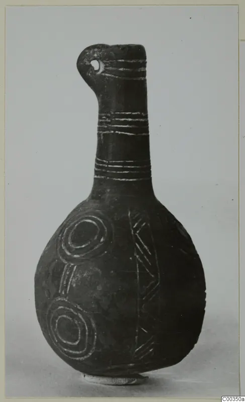 Black polished vessel with a long neck, a pierced lug at the rim, and incised bands, concentric circles and chevrons on the body