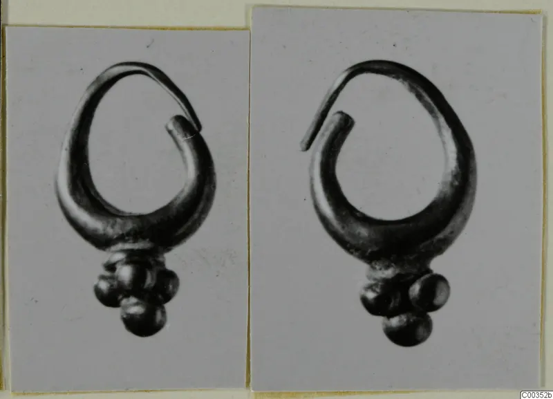 Two photographs of a gold earring with a looped wire and a cluster of small round beads, from Lapithos Tomb 417