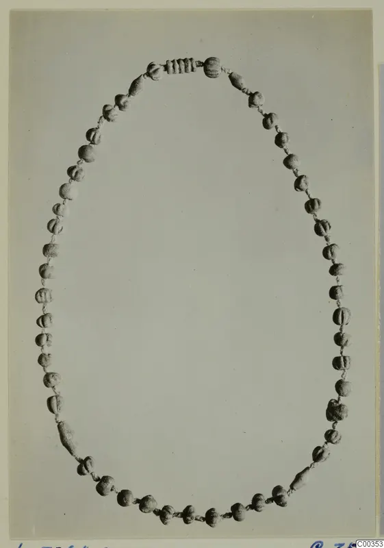 Necklace of about fifty small beads strung on cord and laid out in an oval loop from Lapithos