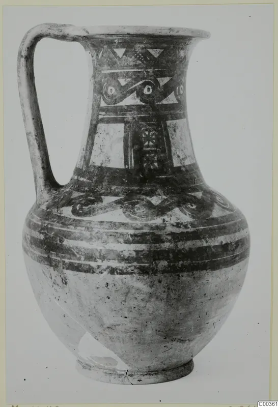 Bichrome wheel-made jug with a strap handle and painted bands and scroll motifs on the neck and shoulder