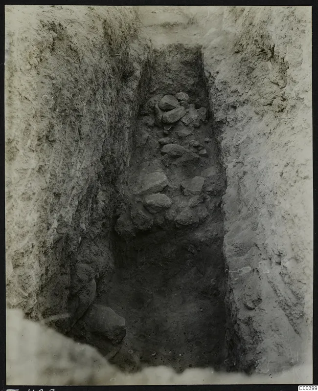 Excavation cutting at Tomb 428 at Lapithos, with stones lying in the narrow trench
