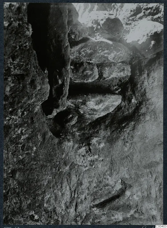Tomb 10 at Milia during excavation, showing the rock-cut tomb chamber with stone slabs lying against its walls