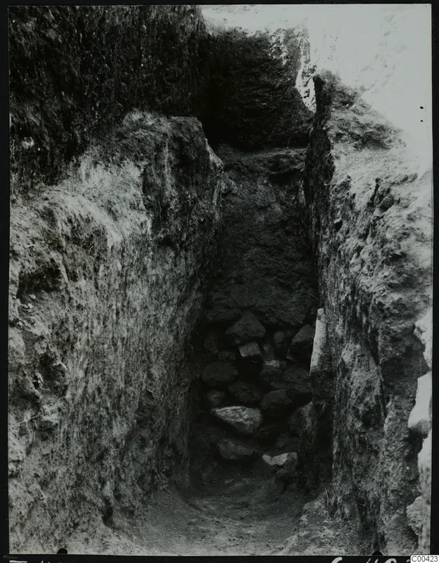 Narrow excavated cutting at Lapithos Kastros, Tomb 420, with a heap of stones at its base