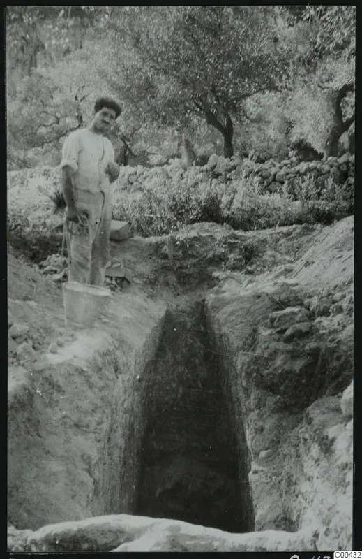 Tomb 410 at Lapithos during excavation: a man with a bucket beside the cut leading to the tomb chamber entrance