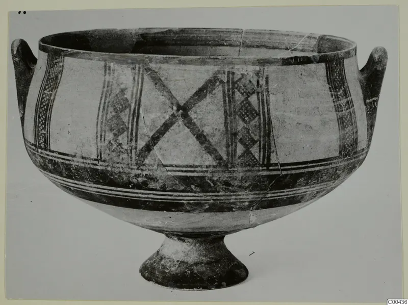 Pottery White Painted I bowl with two handles and a pedestal foot, decorated with crossed bands and lattice panels.
