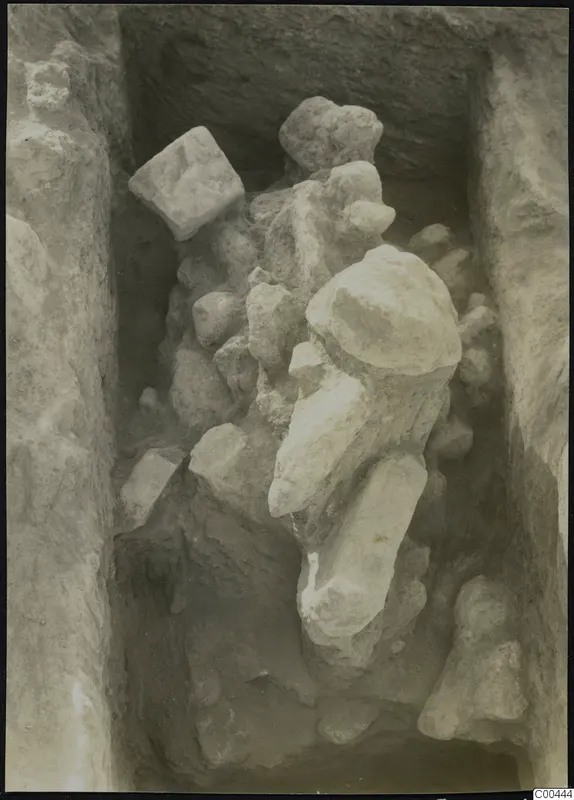 Excavation trench at Plakes, Lapithos, with stones and a large pale stone object lying among them