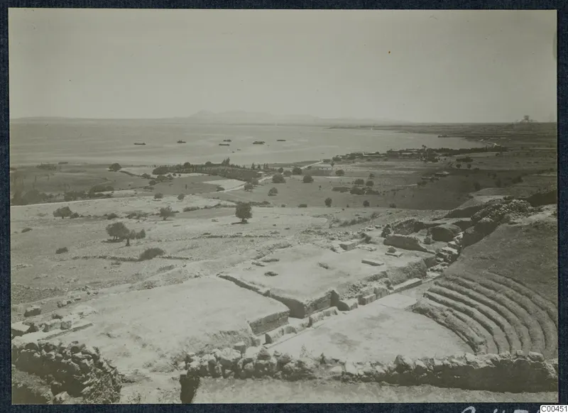 The theatre at Soli, with curved stone seating above a bay where several small boats float