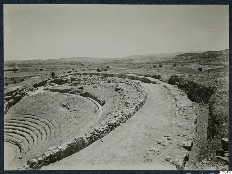 The theatre at Soli, with curved rows of stone steps and a stone retaining wall above a cleared path