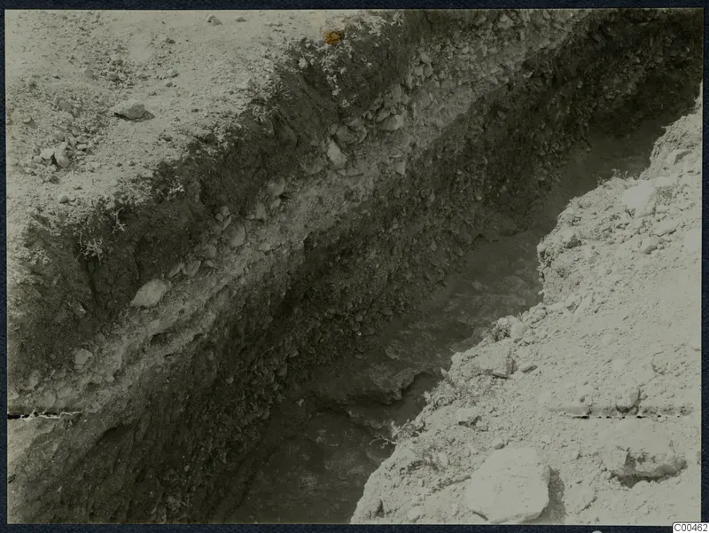 Excavation trench at Soli showing layered dark soil and stones in its sides