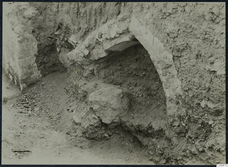 Excavation at Soli showing a curved stone construction set into a cut face of soil