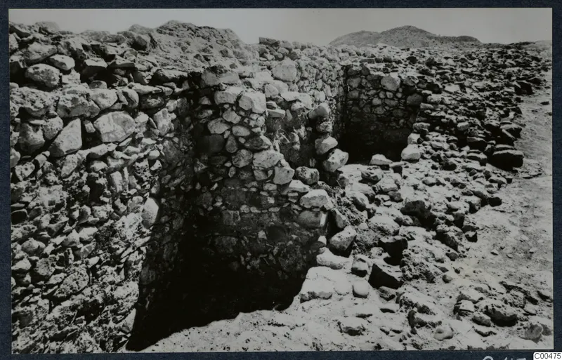 Rubble stone walls and a dark recess during excavation at Soli, the theatre