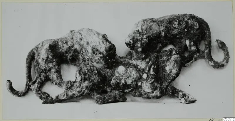 Corroded bronze sculpture of two animals in one group, one rising above the other, with curled tails