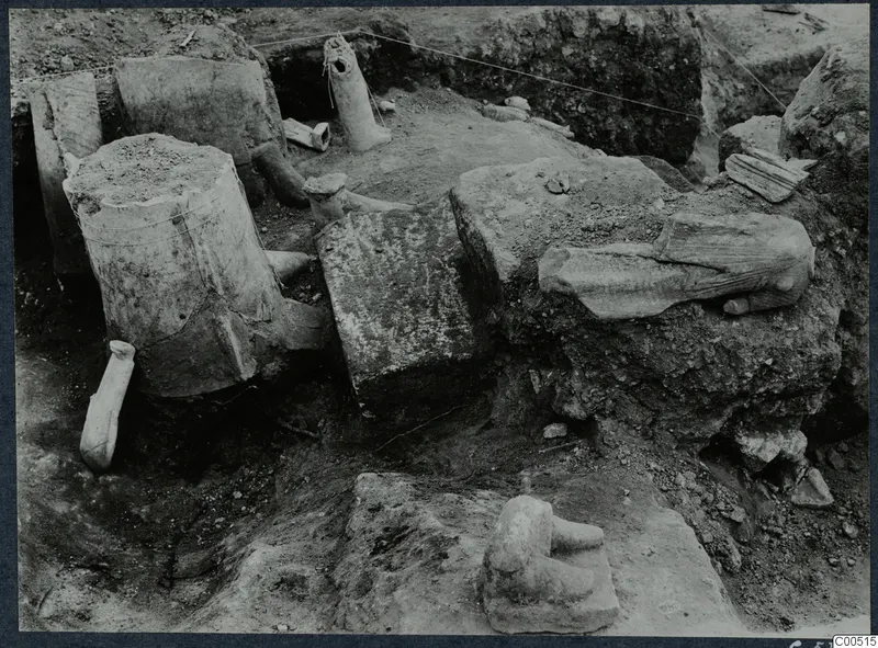 Finds in situ during excavation at Vouni Palace, with large stone blocks and clay fragments lying in a trench.