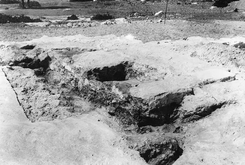 Broken-through floor in Room I of the Temple of Athena at Vouni, with pale stone slabs and a dark cavity below.
