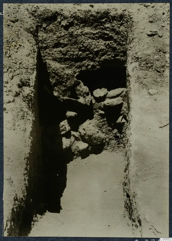 Narrow excavation trench at Vouni with a cavity in the far wall and loose stones and earth in it