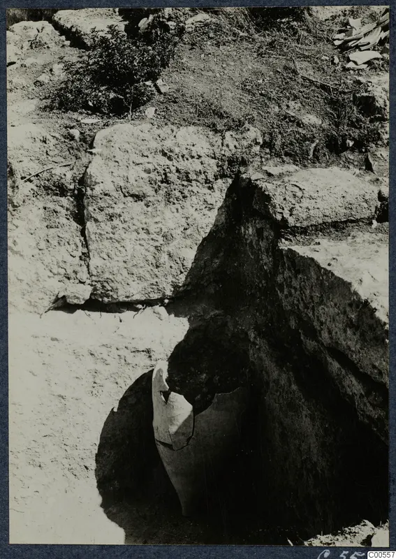 Large broken pottery vessel lying in situ in an excavated pit beside cut stone blocks at Vouni Palace