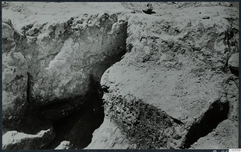 Excavation trench at Vouni with exposed stone walls and cut soil faces.