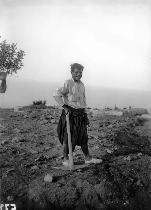 Mavro Keratas smiling and leaning on a hoe on the excavation at Vouni