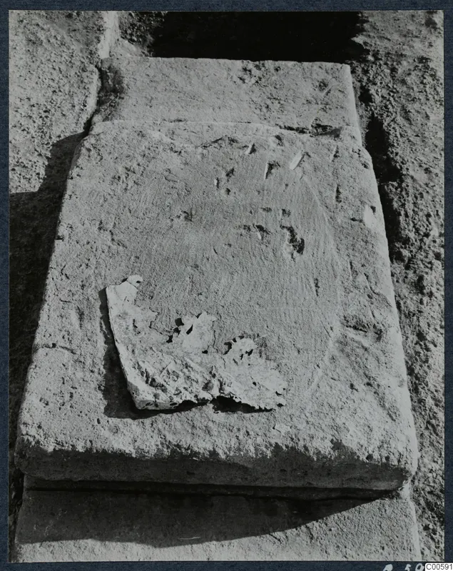 Large stone blocks partly uncovered during excavation at Vouni, one with a broken fragment of stone resting on its face.
