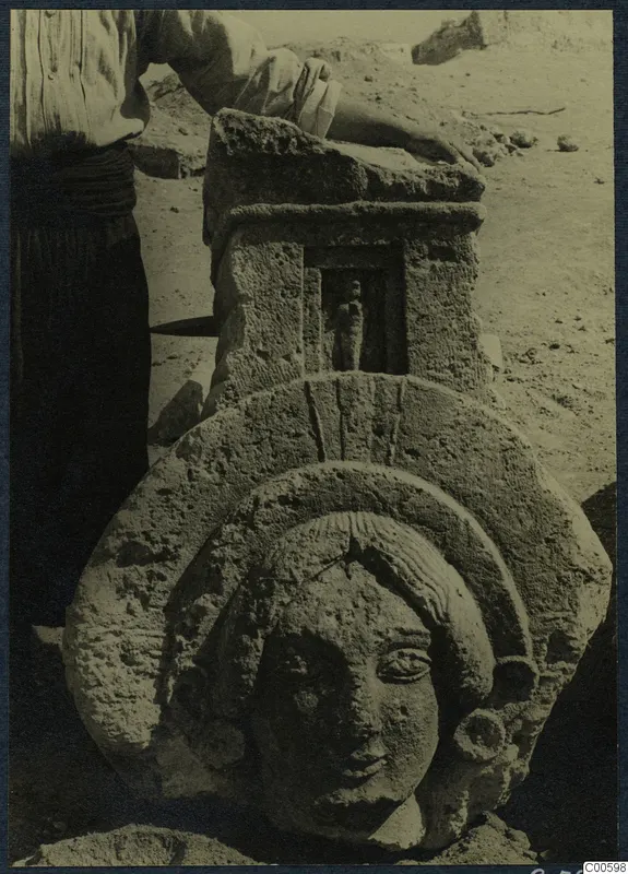 Carved limestone head in relief below a block with a small figure in a niche, from Vouni
