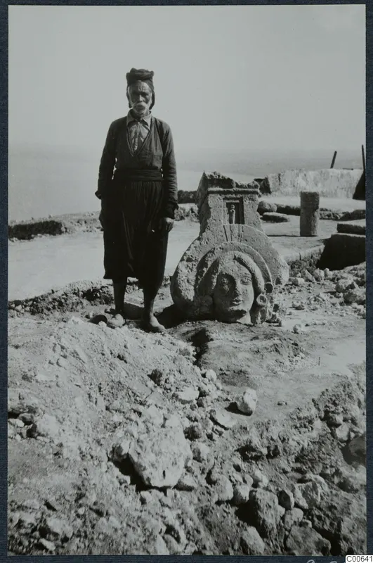 Charalampos, who owned the land, standing beside a sculpted limestone head at Vouni