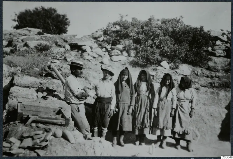 Four women and two men standing in a line in front of a stone wall at Vouni Palace