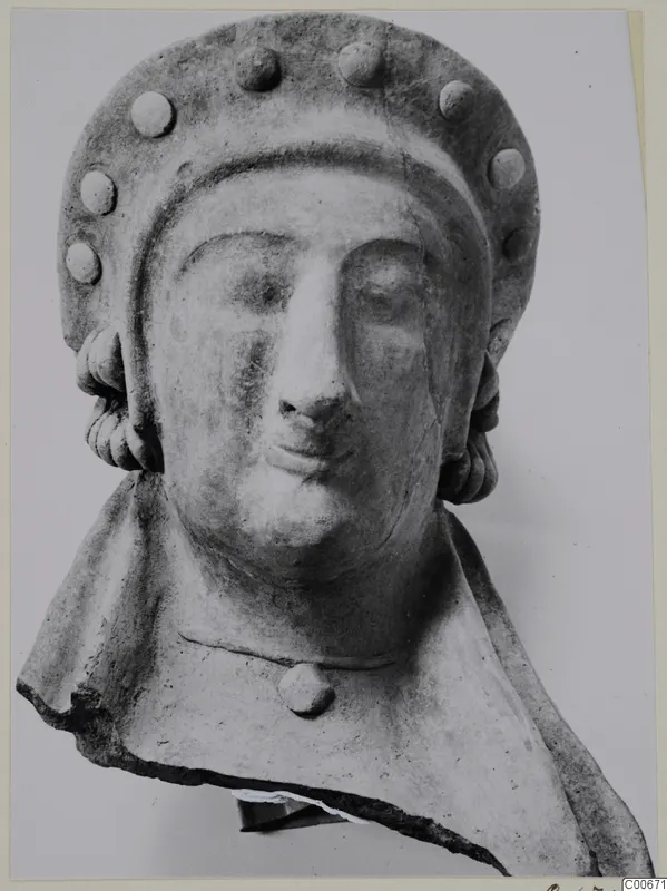Terracotta bust from Vouni with a tall headdress set with round studs, its lower edge broken away.