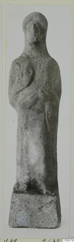 Standing human figurine with arms bent across the body, on a rectangular base, from Vouni