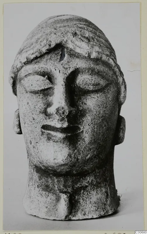 Limestone head of a figure with lowered eyes and banded hair, from Vouni.